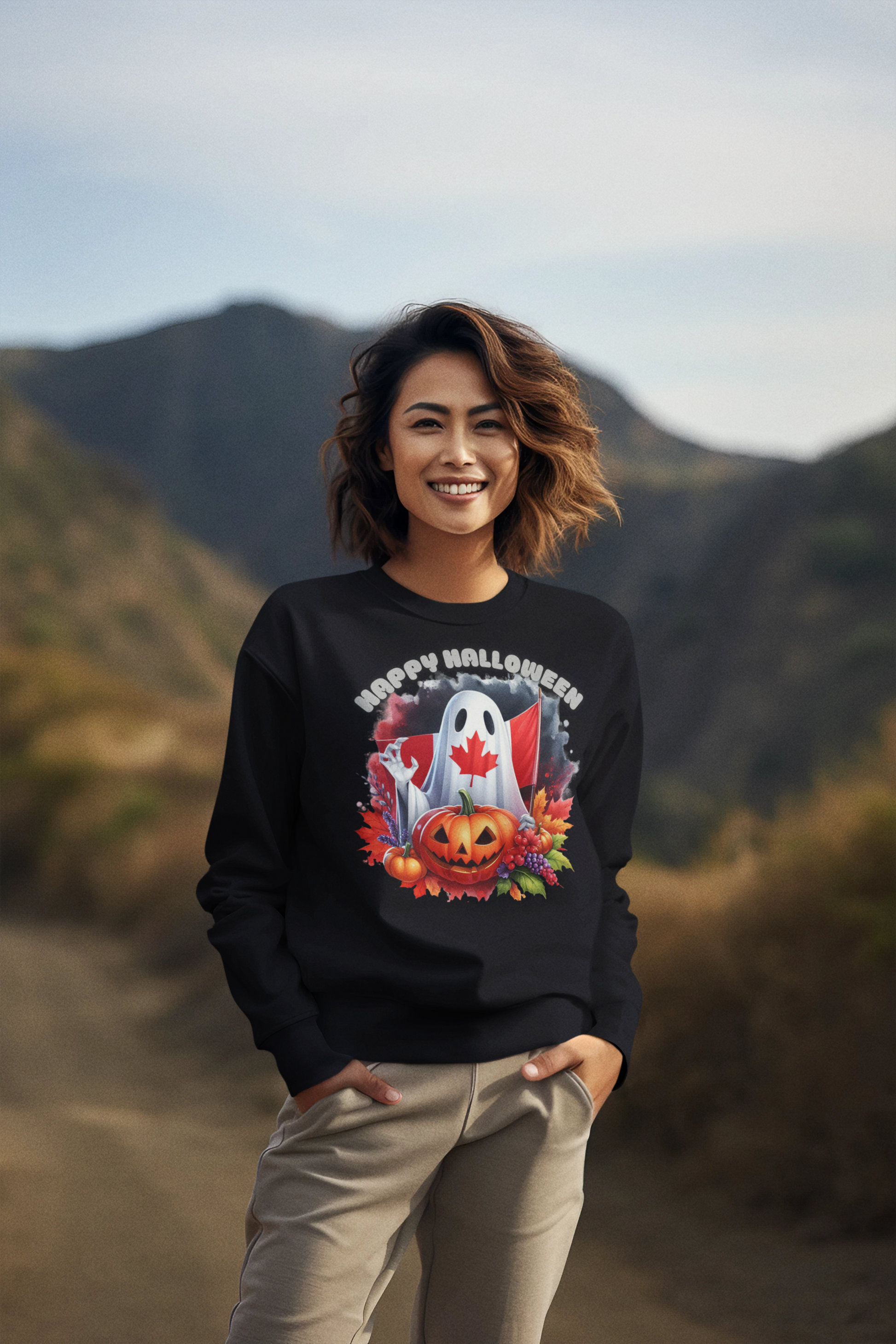 A woman smiles wearing a black sweatshirt with a Canadian Halloween ghost and pumpkin design.