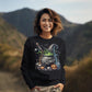 A woman smiles wearing a black sweatshirt with a Halloween cauldron design.