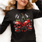 A woman wears a black long-sleeve shirt with a spooky cherry and skull design.