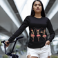 A woman in a black long-sleeve shirt with dancing skeleton ballerinas holds a bike.