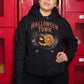 A woman wears a black Halloween Town hoodie with a vintage pumpkin graphic.