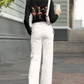 A woman from behind wears a black long-sleeve shirt with dancing skeleton ballerinas.