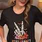 A woman wearing a black t-shirt with a skeleton peace sign and "Stay Creepy" text.