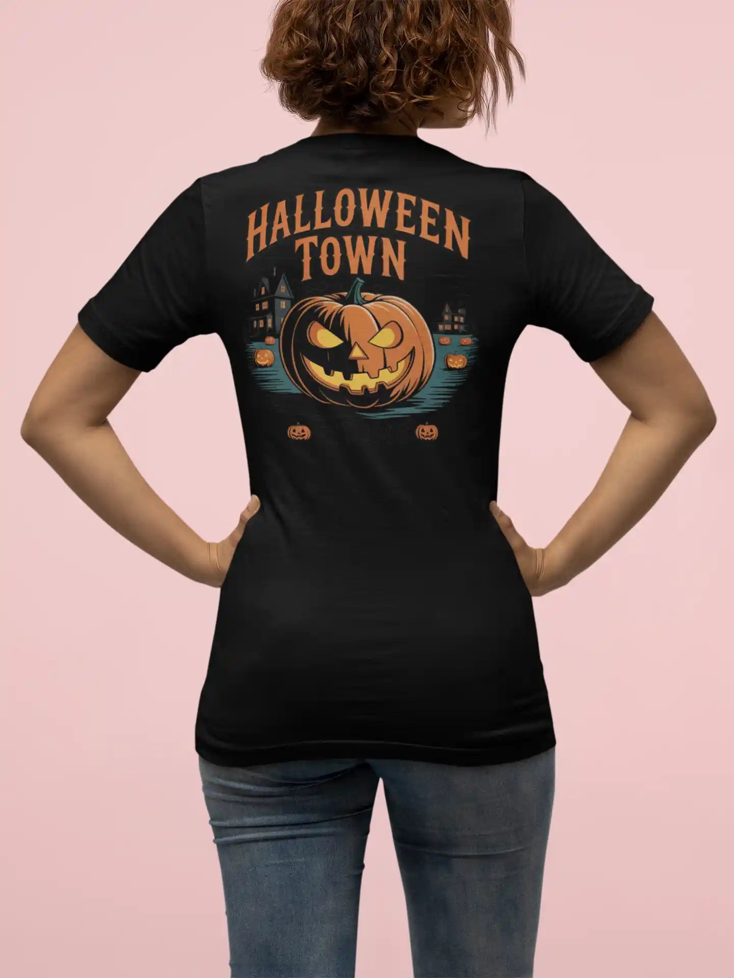 A person from behind wears a black Halloween Town t-shirt with a pumpkin graphic.