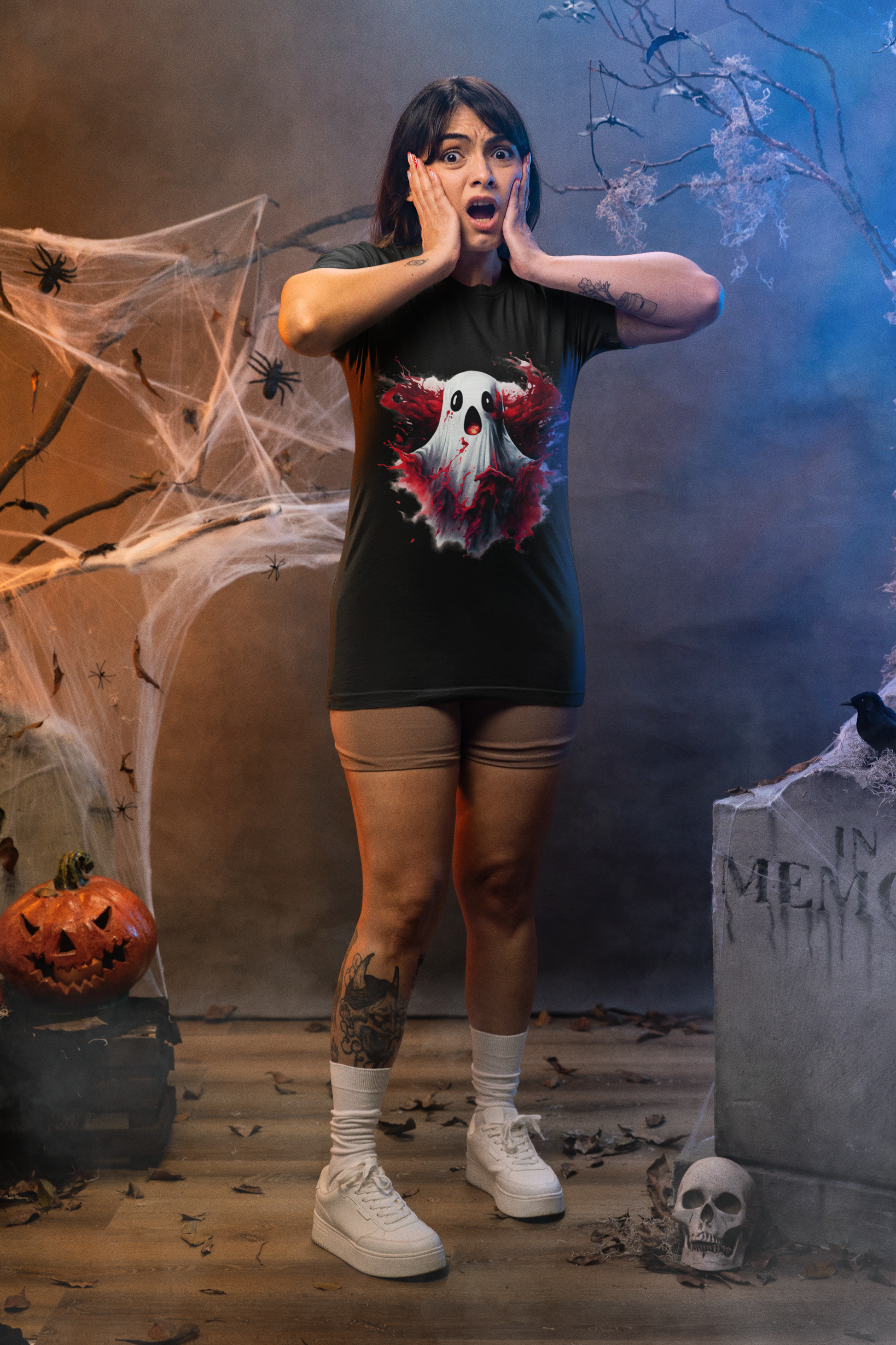 A woman in a black t-shirt with a creepy ghost design stands in a Halloween setting.