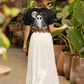 A woman from behind wears a black t-shirt with a ghost design and a long white skirt.