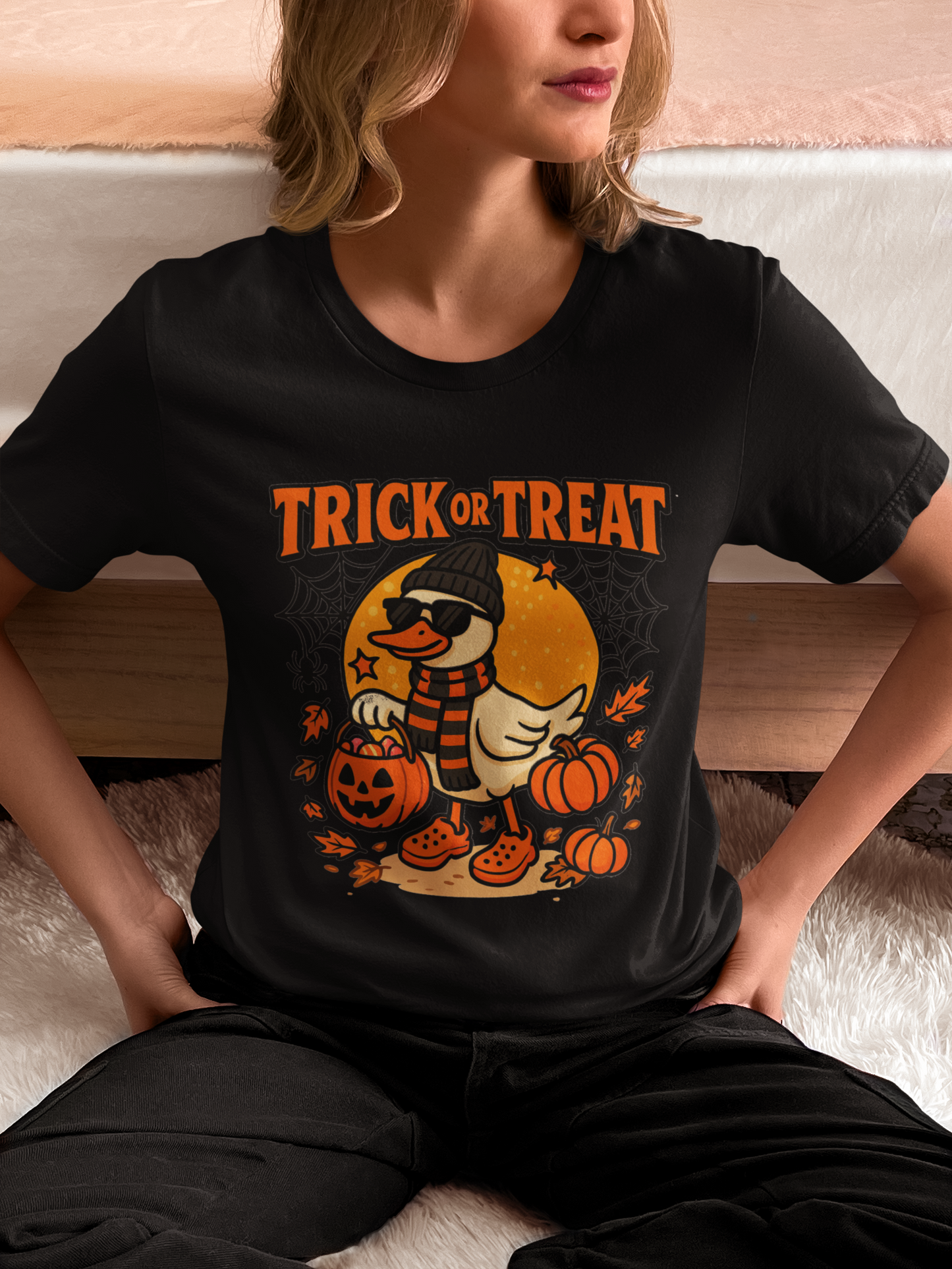 A woman wearing a black t-shirt with a "Trick or Treat" duck graphic.
