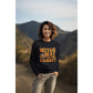 A woman smiles wearing a black "Witch Way to the Candy" Halloween sweatshirt.