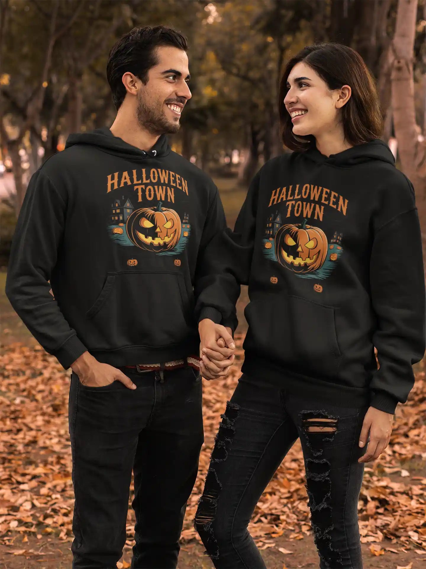 Two people wear black Halloween Town hoodies with a vintage pumpkin graphic.