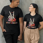 A couple wears black t-shirts with a skeleton hand peace sign and "Stay Creepy" text.