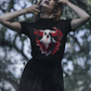A woman wears a black t-shirt with a creepy ghost design.