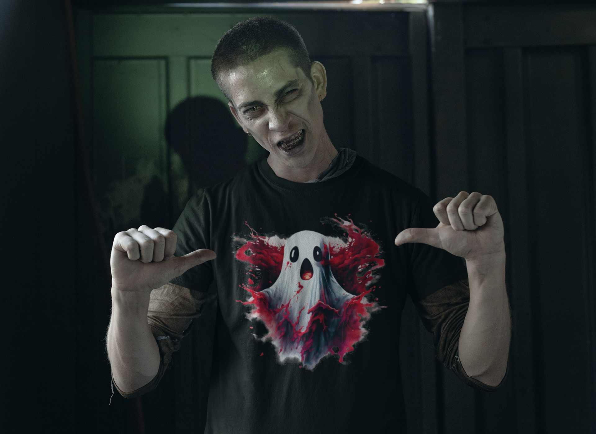 A person with zombie makeup points to a black t-shirt with a creepy ghost design.