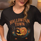 A woman in a beige cap wears a black Halloween Town t-shirt with a pumpkin graphic.