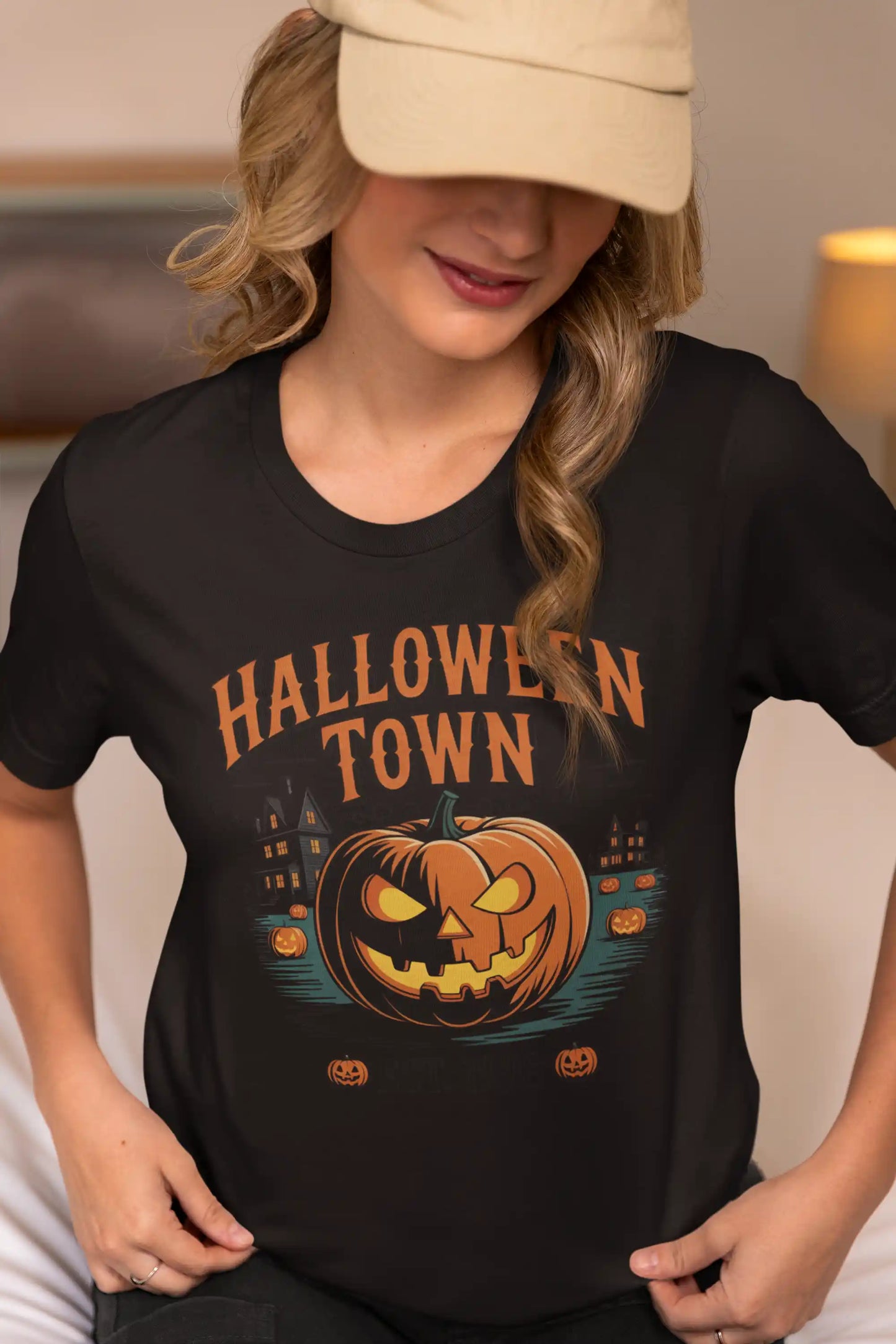 A woman in a beige cap wears a black Halloween Town t-shirt with a pumpkin graphic.