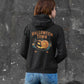 A person from behind wears a black Halloween Town hoodie with a vintage pumpkin graphic.