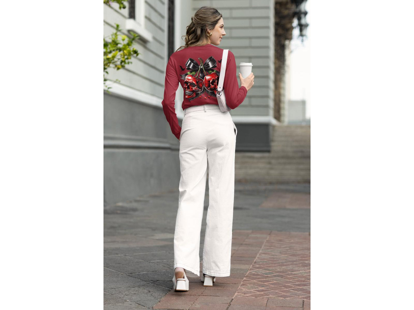 A woman from behind wears a red long-sleeve shirt with a spooky cherry design.