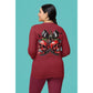A woman from behind wears a red long-sleeve shirt with a spooky cherry Halloween bow design.