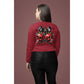 A woman from behind wears a red long-sleeve shirt with a spooky cherry and bow design.