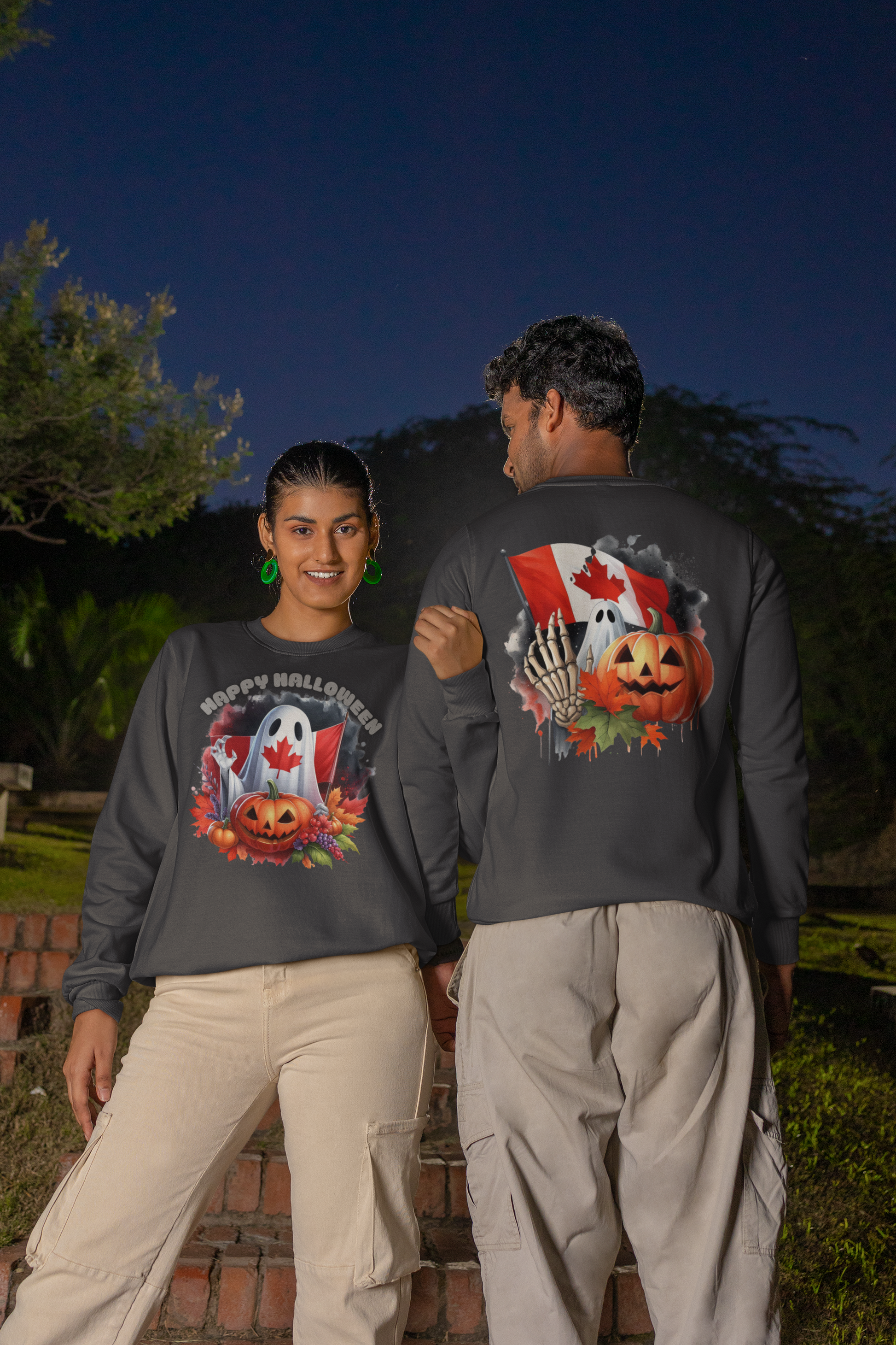 Two people wear dark gray Halloween-themed sweatshirts with Canadian flag elements.