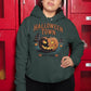 A woman wears a dark green hoodie with a "Halloween Town" pumpkin graphic.