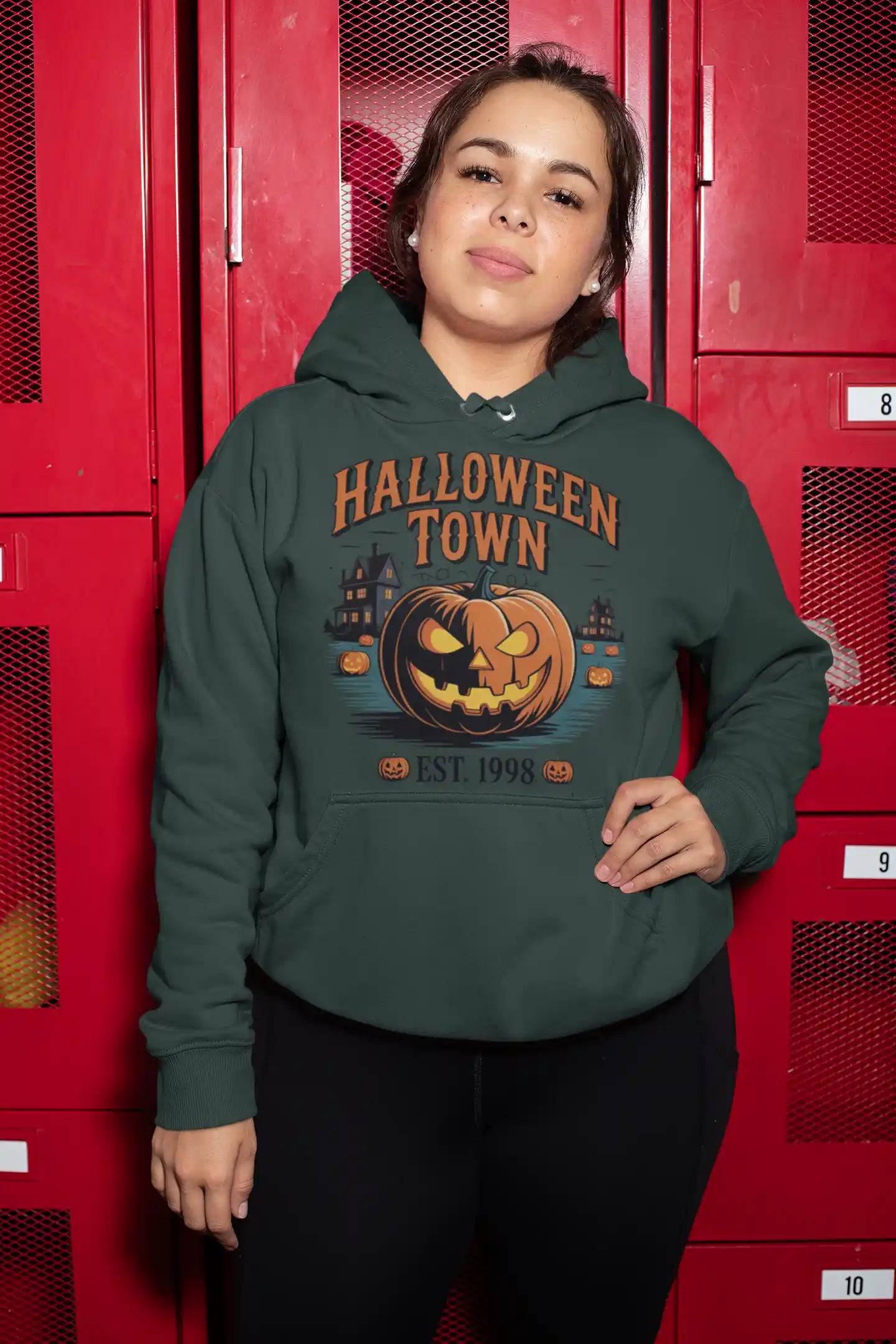A woman wears a dark green hoodie with a "Halloween Town" pumpkin graphic.