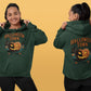 A woman models a dark green Halloween Town hoodie with a pumpkin graphic.