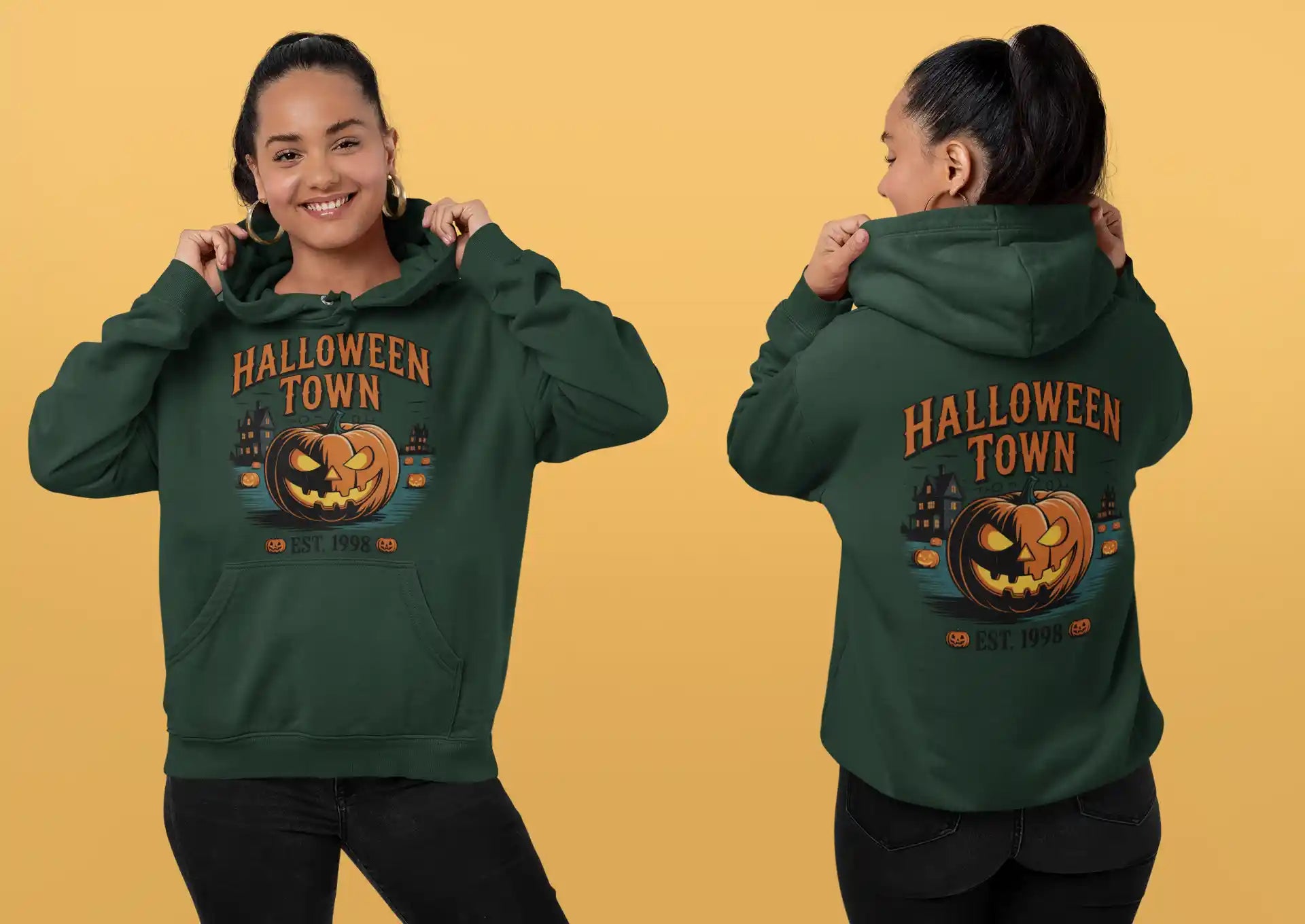 A woman models a dark green Halloween Town hoodie with a pumpkin graphic.
