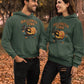Two people wear matching green "Halloween Town" hoodies with a pumpkin graphic.