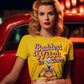 A woman in a yellow "Baddest Witch in Town" t-shirt sits in a red car.