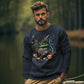 A man wears a navy sweatshirt with a "Happy Halloween" witch's cauldron design.