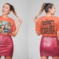 A woman models a short-sleeve orange t-shirt with an anime-style graphic on the front and text on the back.