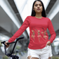 A woman in a red long-sleeve shirt with dancing skeletons and white shorts.