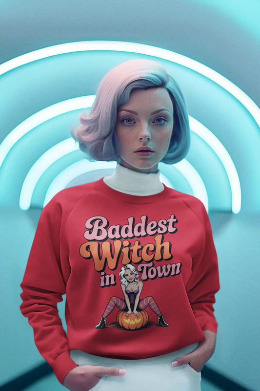 A woman wears a red sweatshirt with "Baddest Witch in Town" and a witch graphic.