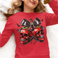 A woman wears a red long-sleeve shirt with a spooky cherry and skull design.