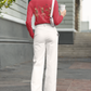 A woman wears a red long-sleeve shirt with dancing skeleton ballerinas on the back.