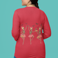 A woman in a red long-sleeve shirt with dancing skeleton ballerinas on the back.