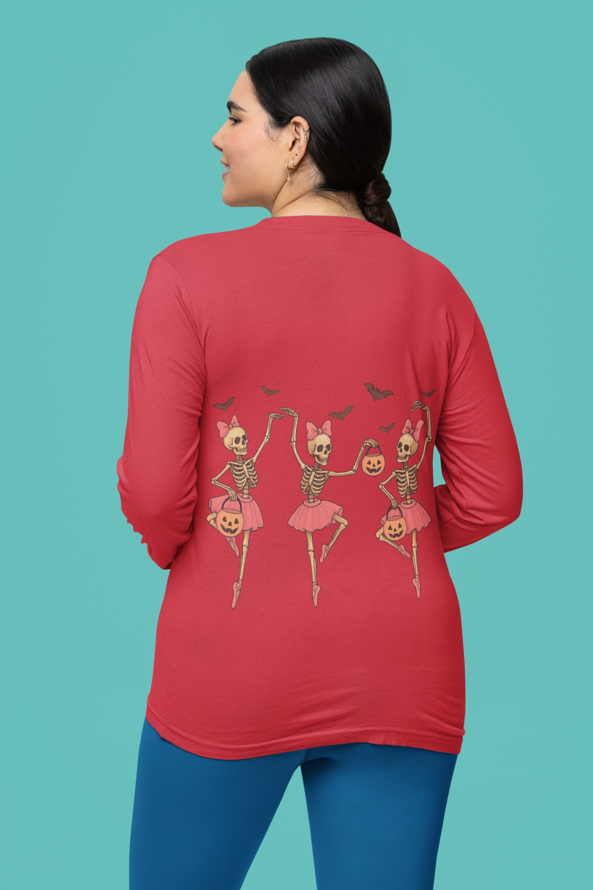A woman in a red long-sleeve shirt with dancing skeleton ballerinas on the back.