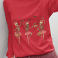 A woman wears a red long-sleeve shirt with three dancing skeleton ballerinas.