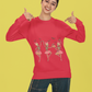 A woman in a red long-sleeve shirt with dancing skeleton ballerinas points to her shirt.