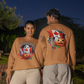 Two people wear matching tan long-sleeve Halloween-themed sweatshirts with Canadian flag designs.