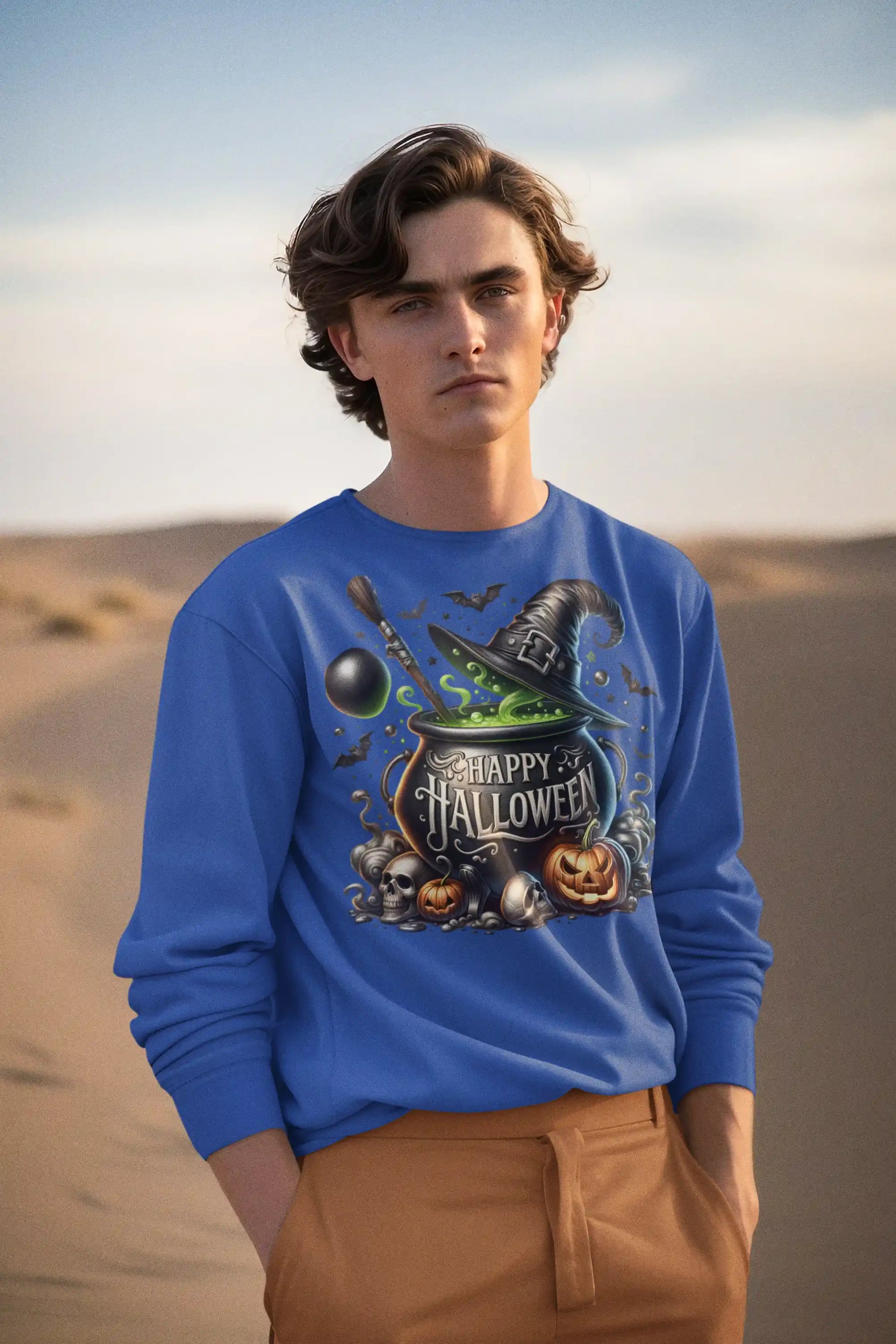 A man in a blue "Happy Halloween" sweatshirt stands in a desert landscape.