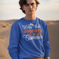 A man wears a blue "Hello Fall GOODBYE Summer" sweatshirt with brown pants.
