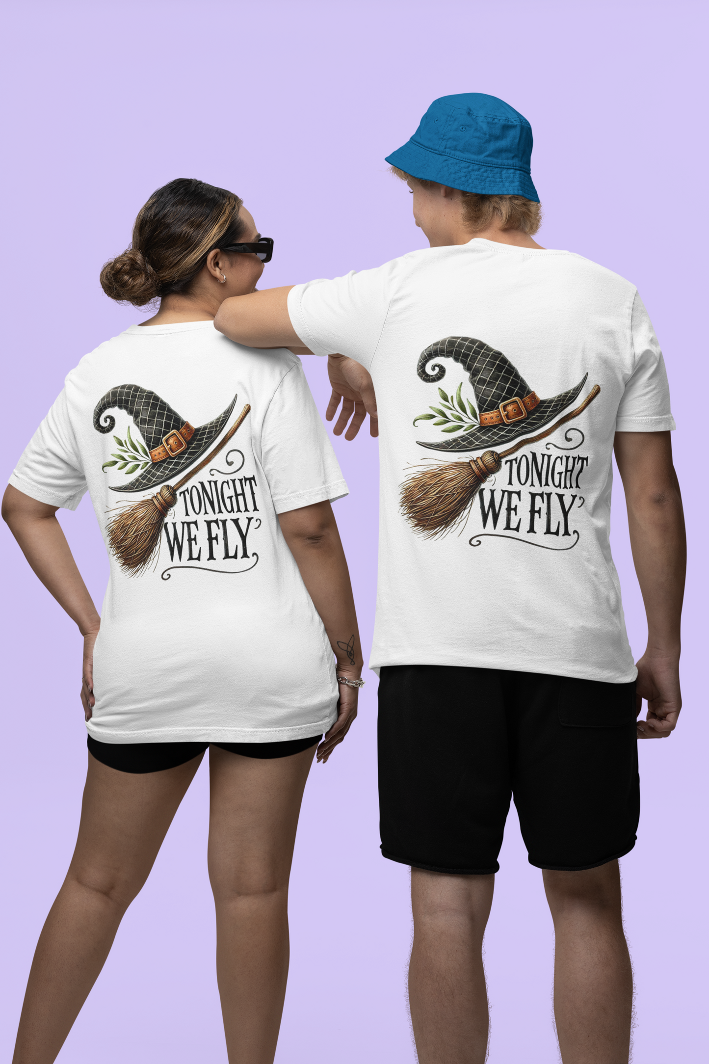 Two people wear white t-shirts with a witch hat and broom design that says "Tonight We Fly."