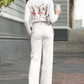 A woman wears a white long-sleeve shirt with dancing skeleton ballerinas on the back.