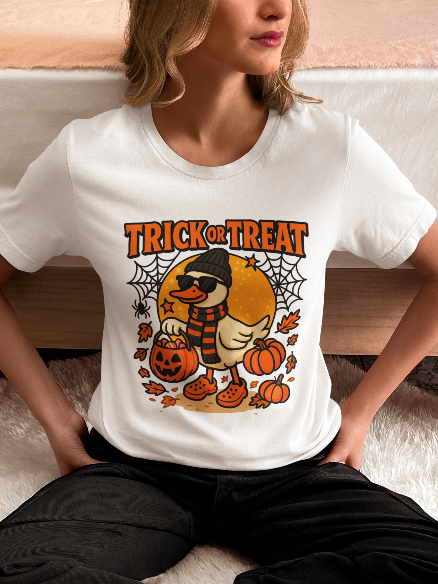 A woman wears a white t-shirt with a Halloween duck graphic.