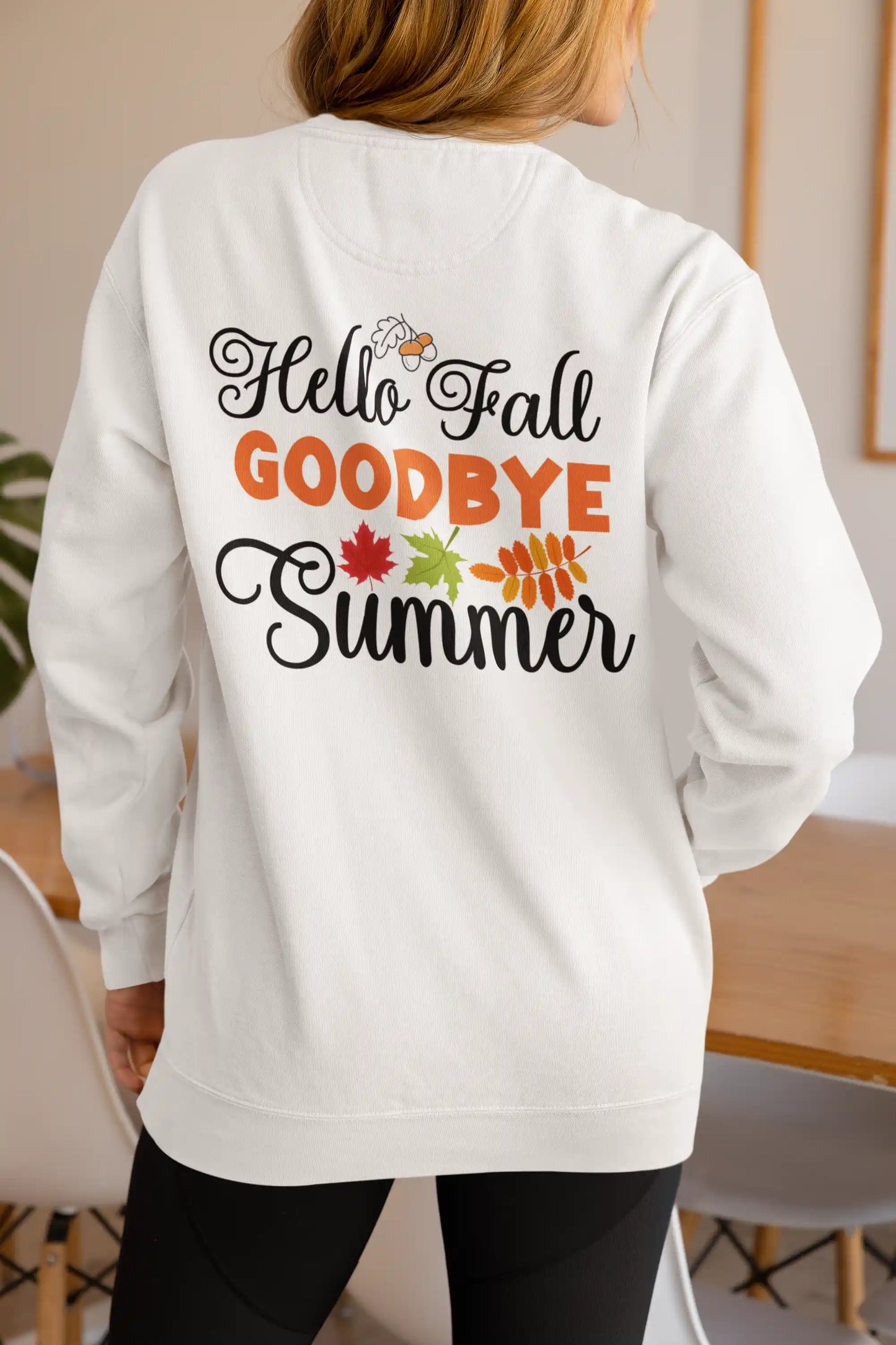 A woman from behind wears a white "Hello Fall GOODBYE Summer" sweatshirt.