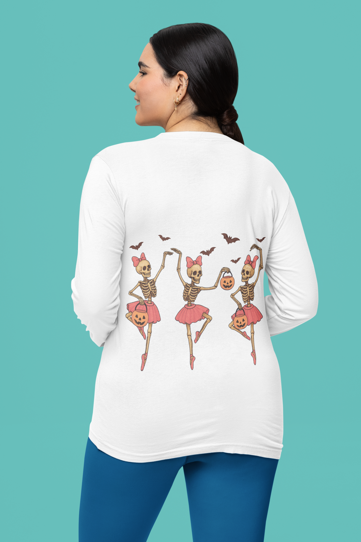 A woman from behind wears a white long-sleeve shirt with dancing skeleton ballerinas.