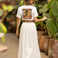 A woman from behind wears a white Halloween duck t-shirt, a long white skirt, and a brown hat.