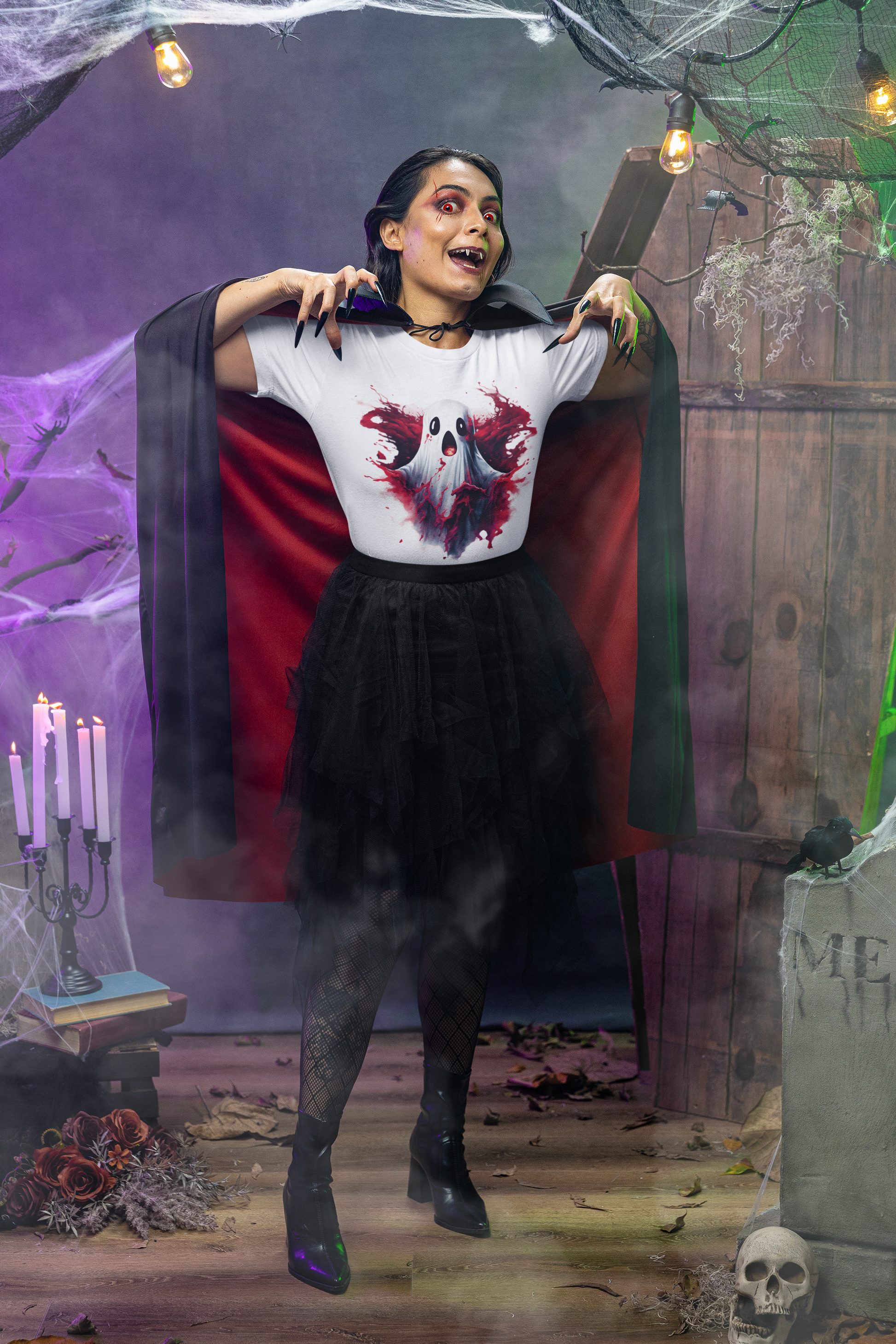 A woman in a vampire costume wears a white t-shirt with a ghost design.