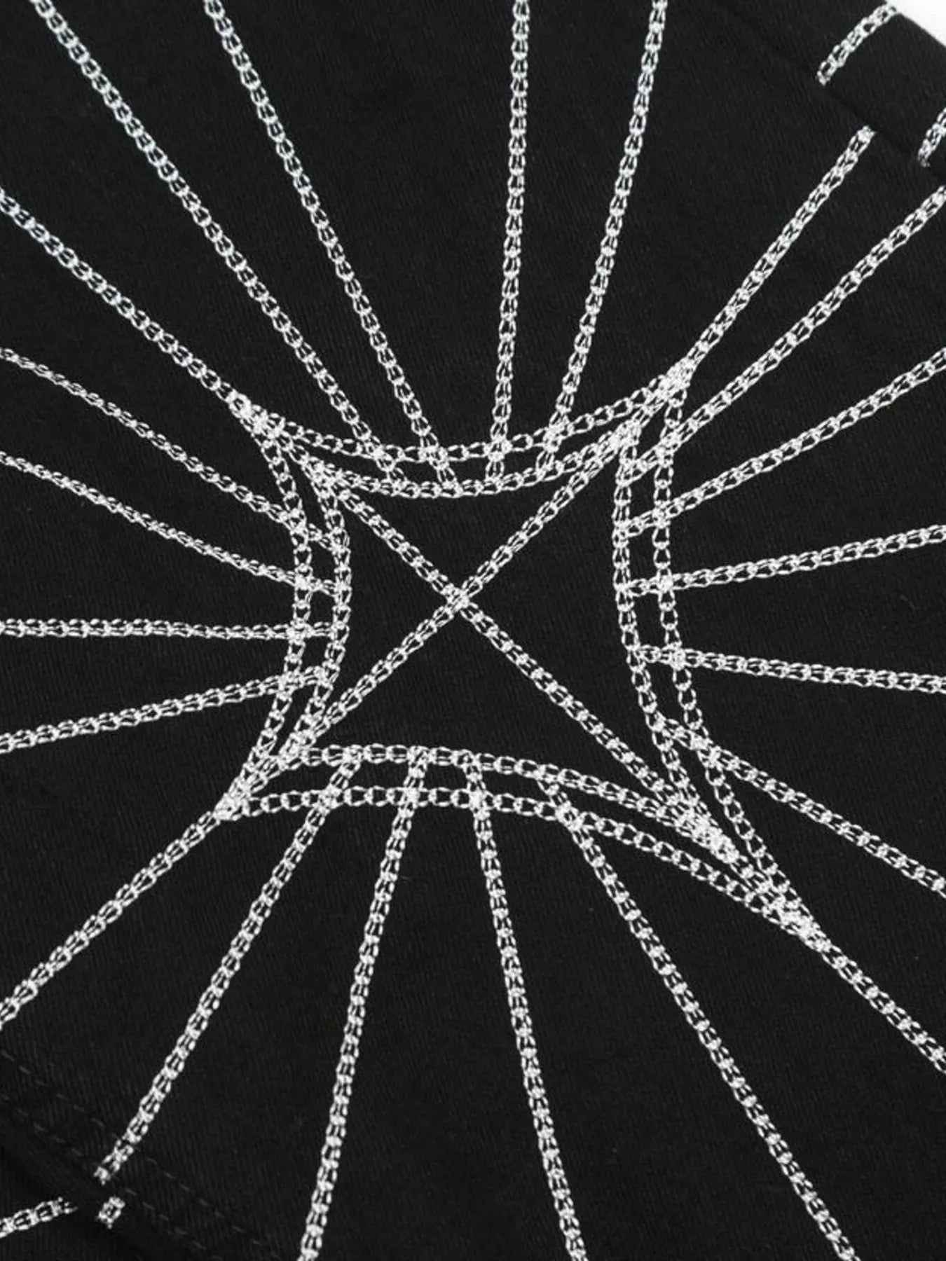 Black flared jeans with white spider web embroidery.